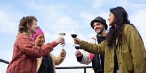 Vrolijke groep proost samen met glazen tijdens een feestje buiten